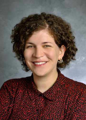 image of woman with brown curly hair smiling and wearing a red shirt, this is rachel the author of this piece